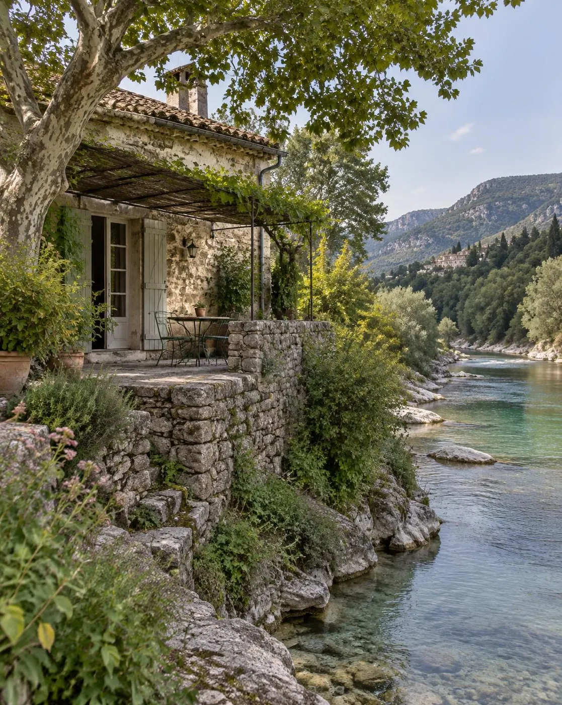 Maison en pierre avec terrasse ombragée au bord d'une rivière